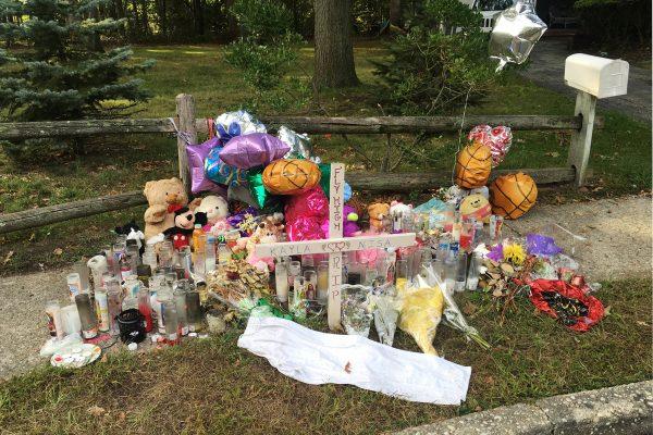 In this Sept. 27, 2016 photo, a memorial for Nisa Mickens and Kayla Cueva is located near the locations where their bodies were found in Brentwood, N.Y. The girls, who were best friends, were found murdered. Multiple teenagers from the same Long Island high school have been found dead and while police suspect all the deaths are related to gang violence, they are releasing few details. (Claudia Torrens/AP Photo)