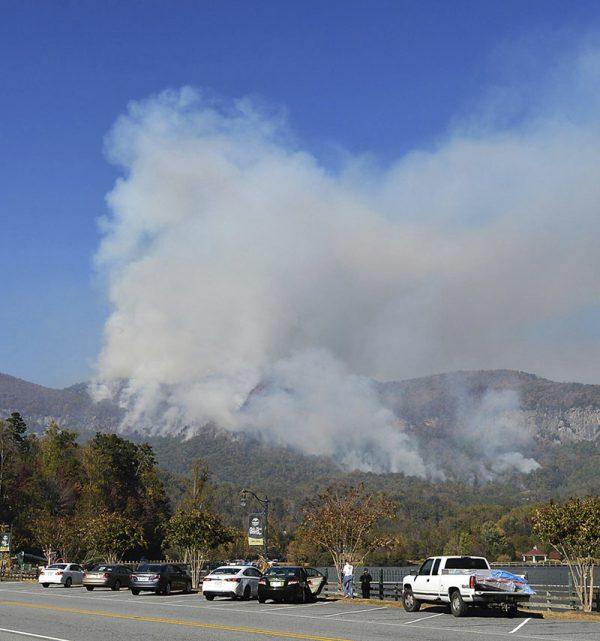 People take photos of a wildfire burning near Lake Lure, N.C., on Nov. 10, 2016. (Patrick Sullivan/The Times-News via AP)