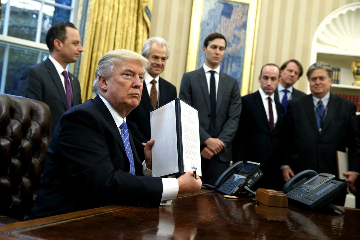 Then-President Donald Trump shows a signed executive order to reinstitute a policy barring any recipient of U.S. assistance from performing or promoting abortions abroad with money they receive from non-U.S. sources in the Oval Office of the White House in Washington on Jan. 23, 2017. (AP Photo/Evan Vucci)