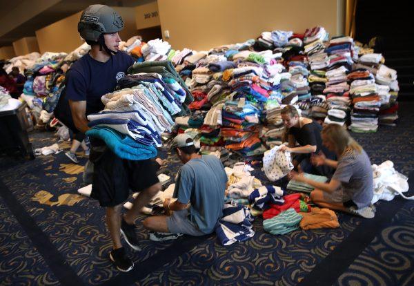 Volunteers organize donated emergency supplies at the temporary shelter at the Lakewood Church on Aug. 29, 2017, in Houston, Texas. Thousands of Houston area residents sought shelter due to flooding caused by the impact of Hurricane Harvey. (Win McNamee/Getty Images)