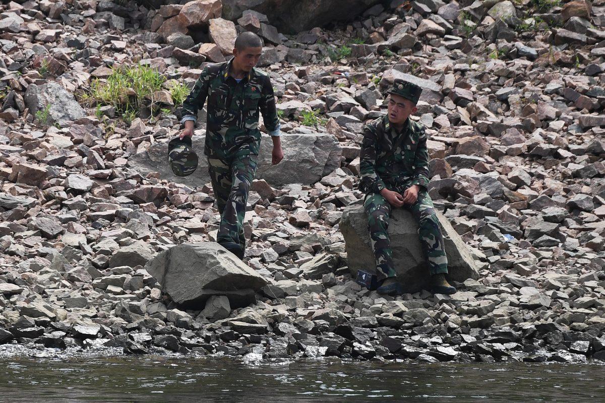 Two North Korean soldiers chat on the bank of the Yalu river near the North Korean town of Sinuiju, opposite the Chinese border city of Dandong, in China's northeast Liaoning province on Sept. 4, 2017. (GREG BAKER/AFP/Getty Images)