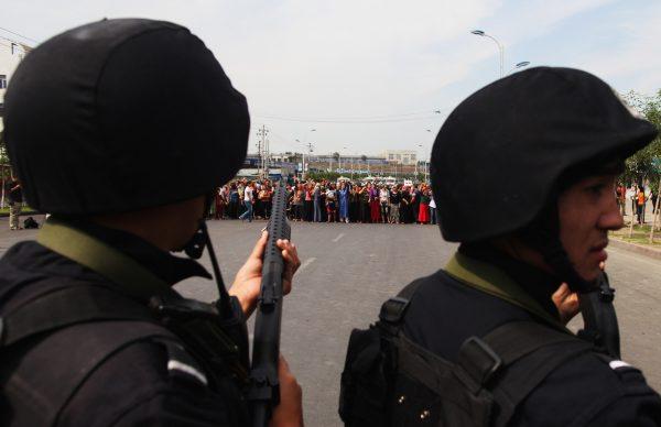 Uyghurs protest in front of policemen in Urumqi on July 7, 2009. (Guang Niu/Getty Images)