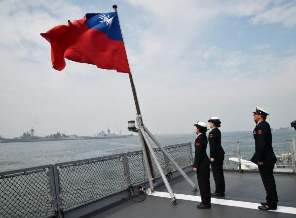 Taiwanese sailors salute the nation’s flag on the deck of the Panshih supply ship at the Tsoying naval base in Kaohsiung on Jan. 31, 2018. (Mandy Cheng/AFP/Getty Images)