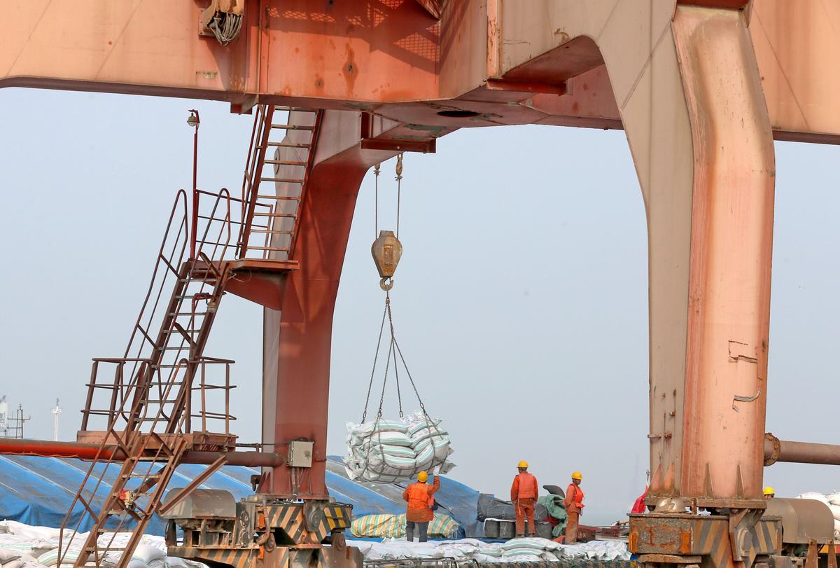 Chinese workers transfer bags of soybean meal at a port in Nantong City, Jiangsu Province, on March 22, 2018. (AFP/Getty Images)