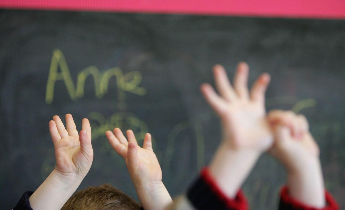 Children wave their hands at a private nursery school. (Christopher Furlong/Getty Images)