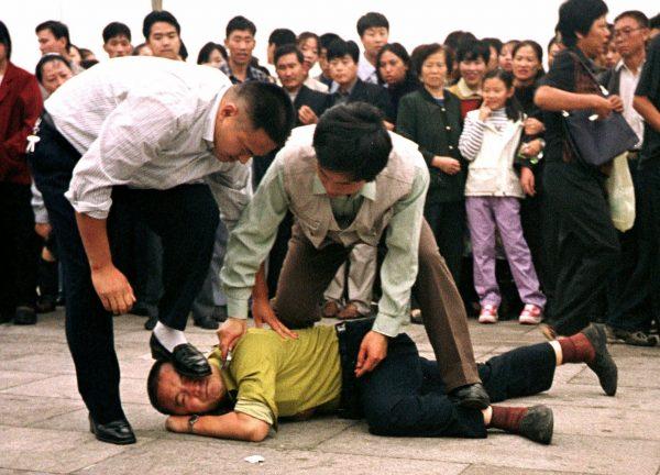 Police arrest a Falun Gong protester on Tiananmen Square in Beijing on Oct. 1, 2000. (AP Photo/Chien-min Chung)