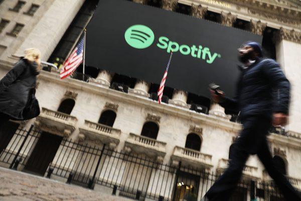 People walk by the New York Stock Exchange (NYSE) on the morning that the music streaming service Spotify begins trading shares at the NYSE in New York City on April 3, 2018. (Spencer Platt/Getty Images)