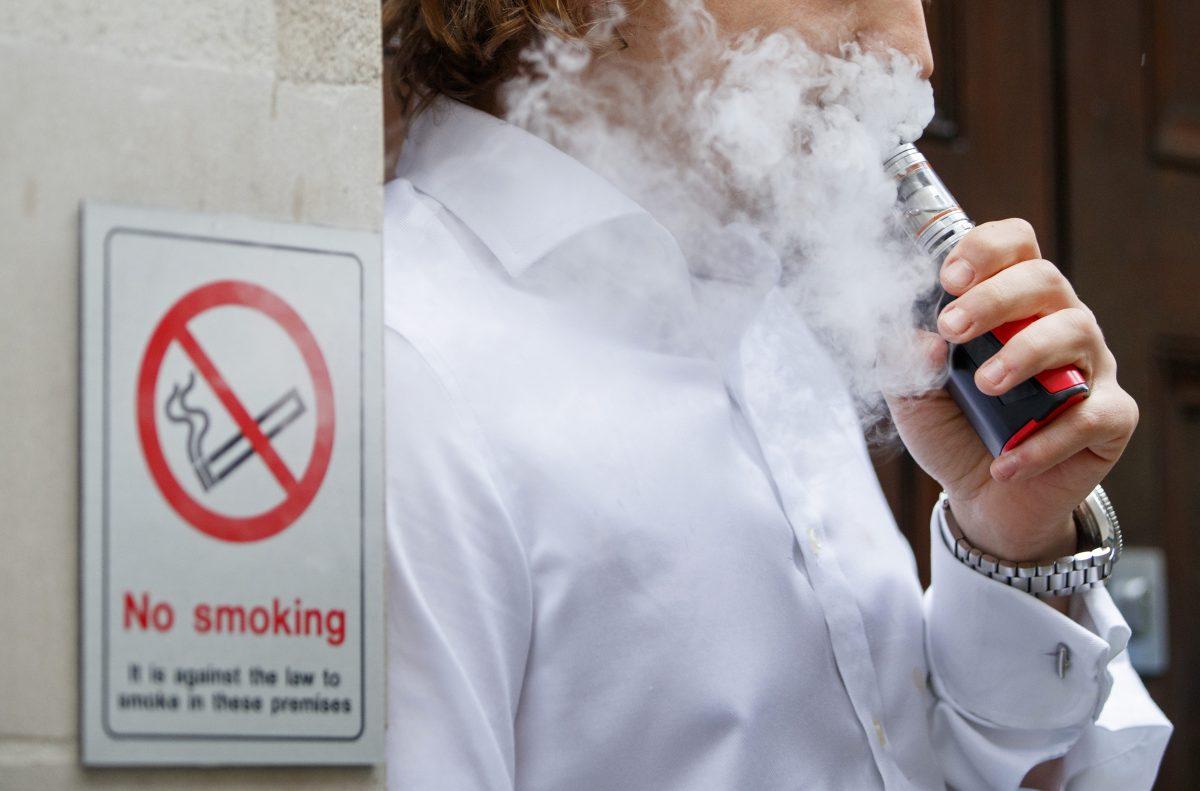 A smoker is engulfed by vapors as he smokes an electronic vaping machine during lunch time in central London on Aug. 9, 2017. (Tolga Akmen/AFP/Getty Images)