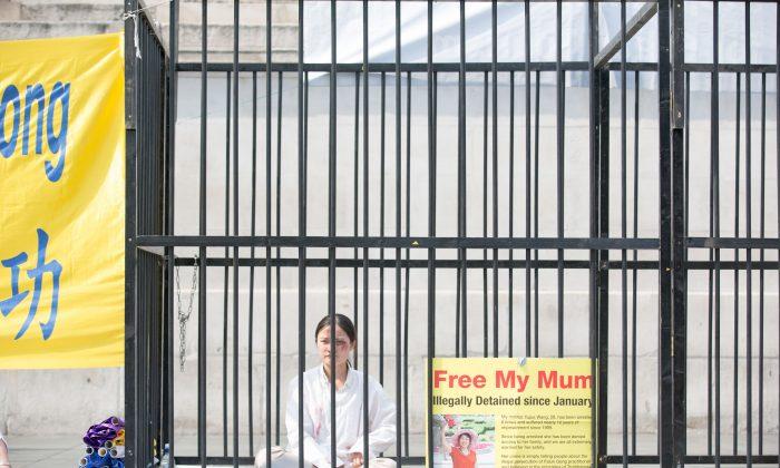 A Falun Gong practitioner sits in London's Trafalgar Square on July 21. The spiritual practice has been persecuted in China since July 20 1999. (Max Lin/Epoch Times)