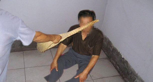A Minghui.org torture reenactment that shows a Falun Gong practitioner being beaten. (Minghui)