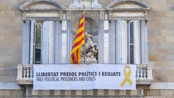 A banner under the Catalan flag on Palau de la Generalitat, the seat of the government of Catalonia, reads “Free political prisoners and exiles,” on Oct. 3, 2018, in Barcelona, Spain. (Anna Llado/Special to The Epoch Times)