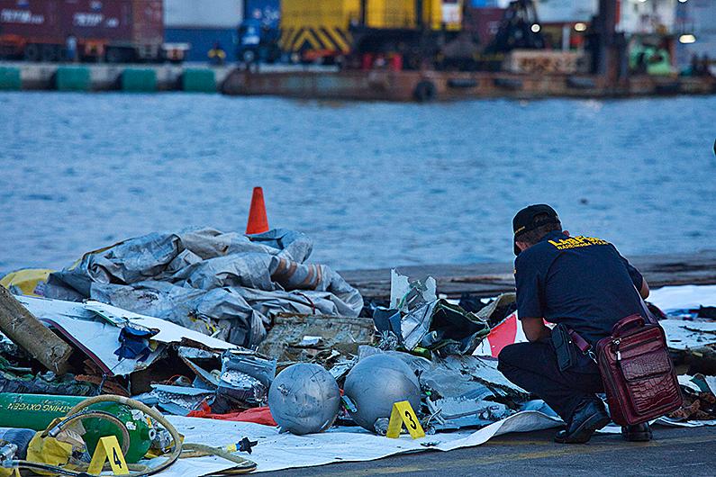 A forensic investigator looks through the remains of Lion Air flight JT610 at the Tanjung Priok port in Jakarta, Indonesia, on Oct. 29, 2018. (Ed Wray/Getty Images)