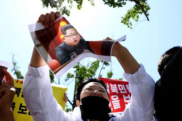 A North Korean defector tears a portrait of North Korean leader Kim Jong-Un during a rally in Seoul, South Korea on May 19, 2018. (Chung Sung-Jun/Getty Images)