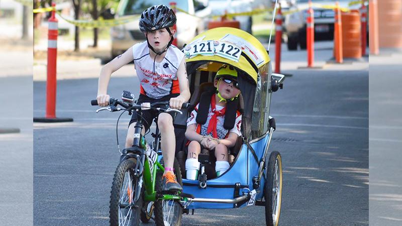 8-year-old boy displays amazing brotherly love by finishing triathlon with disabled sibling