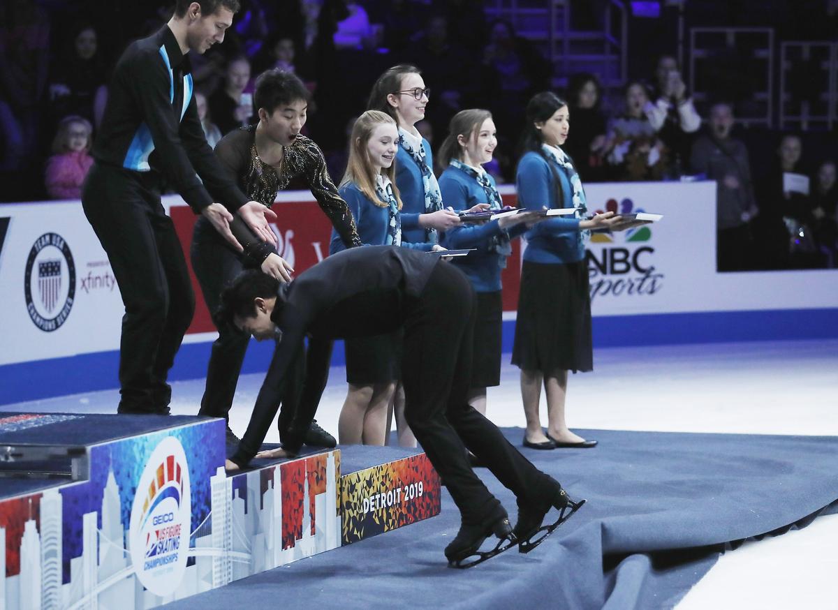 Nathan Chen is helped as he approaches the winner's podium after winning the men's free skate during the U.S. Figure Skating Championships, Jan. 27, 2019, in Detroit. (AP Photo/Carlos Osorio)
