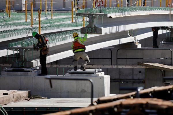 Construction workers guide part of a bridge into place in Baltimore. (David Gannon/AFP/Getty Images)