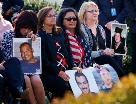 Family members hold portraits of loved ones that were victims of crimes committed by illegal aliens, as President Donald Trump delivers remarks, in the Rose Garden at the White House on Feb. 15, 2019. (Brendan Smialowski/AFP/Getty Images)