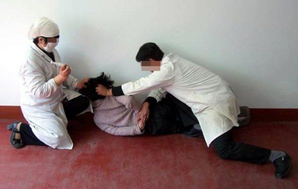 Re-enactment of a victim being forcibly injected with unknown psychiatric drugs. (Minghui.org)