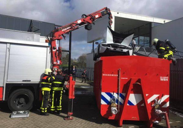 Dutch fire crews used a crane to lift the smoking BMW i8 into the vat of water in Brabant province, on March 25, 2019. (Brandweer Midden- en West-Brabant)