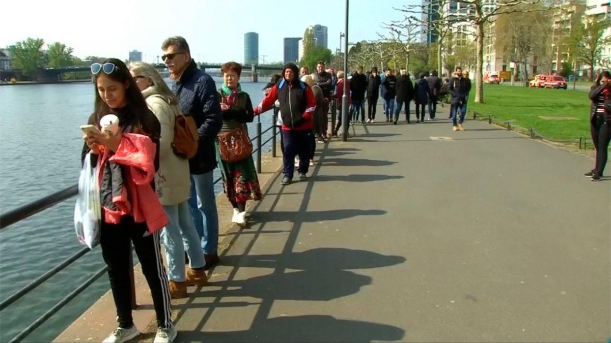 Passers-by are standing afar to witness the underwater defusing of an WWII bomb in Main River, in Frankfurt, Germany, on April 14, 2019. (Screenshot via Reuters)