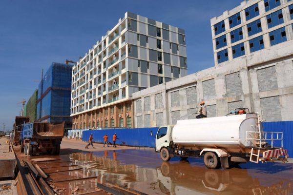 Cambodian workers clean a street at a building construction site in Sihanoukville, the coastal capital of Preah Sihanouk Province, Cambodia, on Dec. 14, 2018. (Tang Chhin Sothy/AFP/Getty Images)