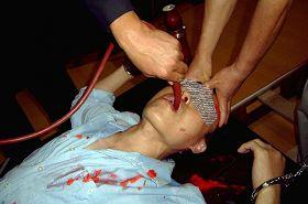 Re-enactment of force-feeding. (Minghui.org)