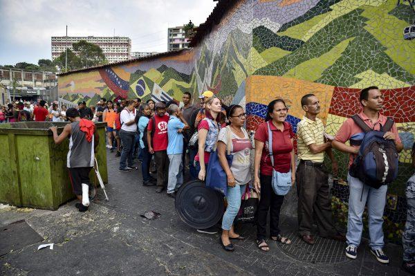 People line up to receive drums to collect water and water purification tablets from the Venezuelan Red Cross in Caracas on April 16, 2019. (Yuri Corteza/AFP/Getty Images)
