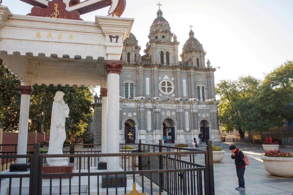 A believer prays outside St. Joseph's Church, a government-sanctioned Catholic church, in Beijing on Oct. 1, 2018. (Thomas Peter/Reuters)