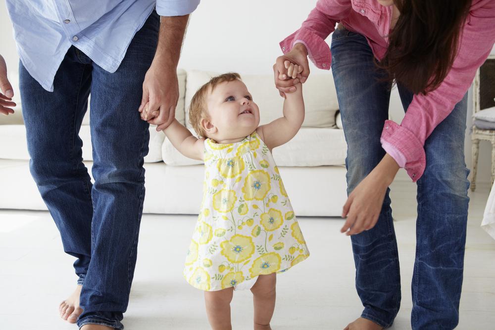 Illustration - Shutterstock | <a href="https://www.shutterstock.com/image-photo/parents-teaching-baby-girl-walk-199711058?studio=1">Monkey Business Images</a>