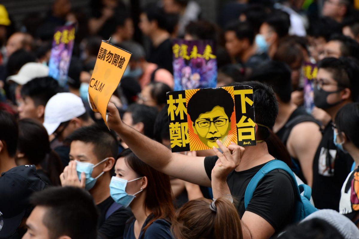One protester holds up a sign that says "Carrie Lam Step Down" in a march in Mong Kok, Hong Kong, on Aug. 3, 2019. (Song Bilong/The Epoch Times)