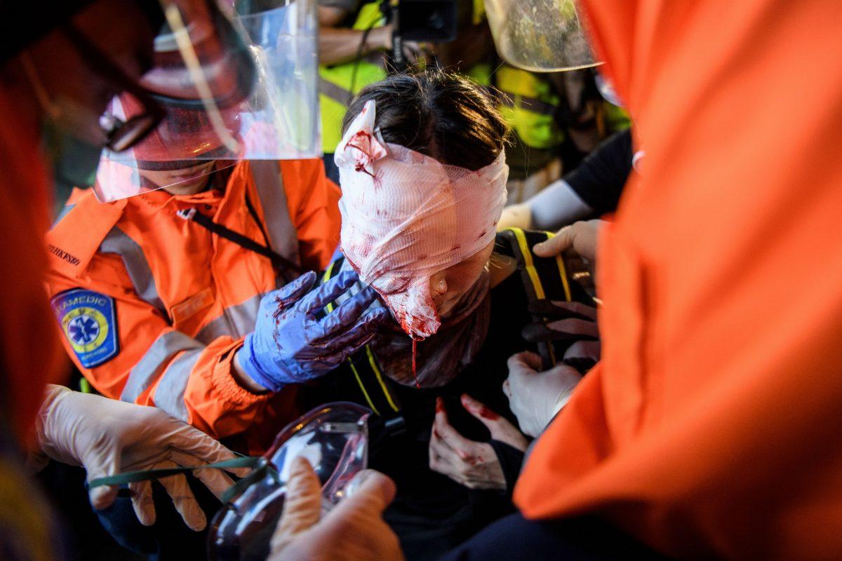 Medics look after a woman who received a facial injury during a standoff between protesters and police in Tsim Sha Tsui in Hong Kong on Aug. 11, 2019. (Anthony Wallace/AFP/Getty Images)