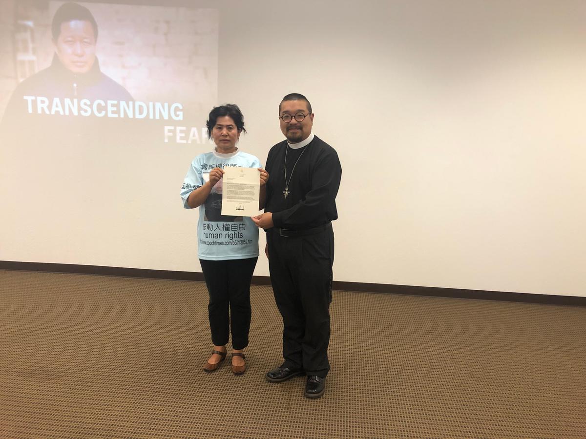 Geng He (L) and Rev. Liu hold a printed letter from President Trump at a news conference on Aug. 11, 2019. (Nathan Su/Epoch Times)