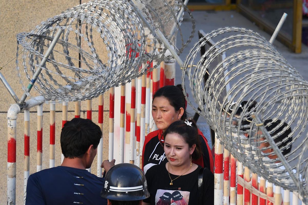 A Uyghur woman (C) going through an entrance to a bazaar in Hotan, in China's northwest Xinjiang region on May 31, 2019. (Greg Baker/AFP/Getty Images)