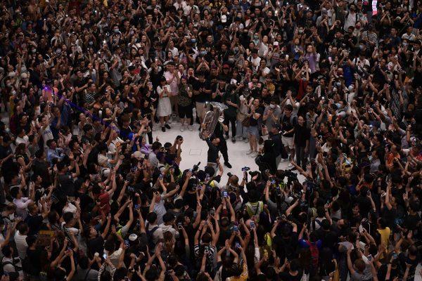 A man (C) plays a tuba as others gather at a shopping mall in the Sha Tin area of Hong Kong to sing a recently penned protest song titled 'Glory to Hong Kong which has been gaining popularity in the city on Sept. 11, 2019. (Nicolas Asfouri/AFP/Getty Images)