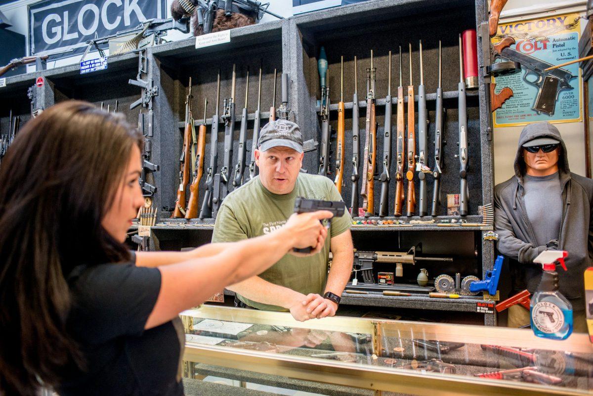 Edward Wilks, owner of Tradesmen Gun Store and Pawnshop, helps Lauren Boebert with a firearm at his store in Rifle, Colorado on April 24, 2018. (Emily Kask/AFP/Getty Images)