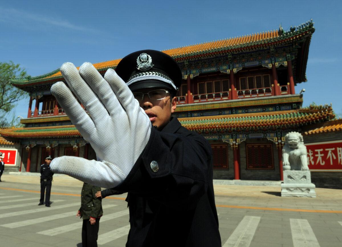 A Chinese policeman blocks photos being taken outside Zhongnanhai, which serves as the central headquarters for the Chinese Communist Party, in Beijing on April 11, 2012. (Mark Ralston/AFP/Getty Images)