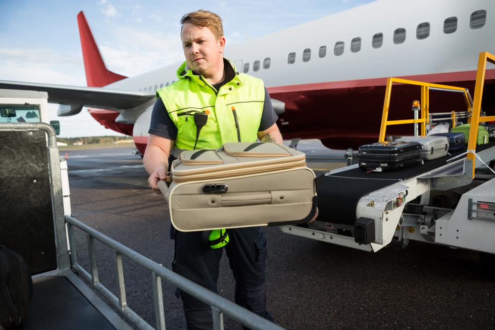 Illustration - Shutterstock | <a href="https://www.shutterstock.com/image-photo/worker-placing-luggage-trailer-against-airplane-791231641?src=PHtaoWNYgiurCI_DbIRqxA-1-0">Tyler Olson</a>