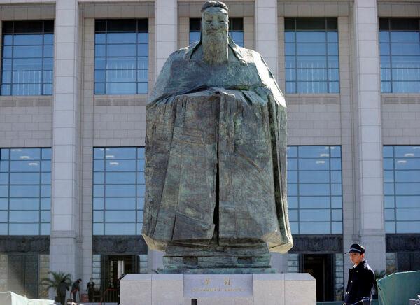 A security man stands beside the statue of the Chinese philosopher Confucius at the entrance of the China National Museum in Beijing on March 1, 2011. (Liu Jin/AFP via Getty Images)