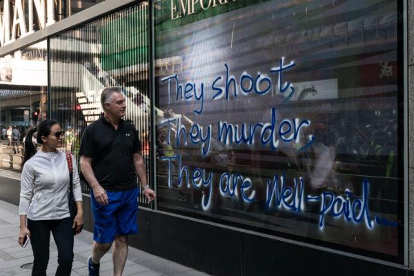 Pedestrians walk past graffiti on a shop display in Hong Kong on Nov. 11, 2019. (Anthony Kwan/Getty Images)