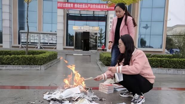 Two workers are seen burning books in front of the Zhenyuan county library in Qingyang City, Gansu Province, on Oct. 22, 2019. (Zhenyuan County official website)