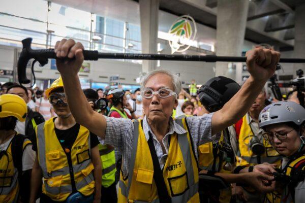 This picture taken on Sept. 7, 2019 shows "Grandpa Wong" (C), 85, shielding protesters from the police by holding his walking stick up along with other "silver hair" volunteers in the Tung Chung district in Hong Kong. (Vivek Prakash/AFP via Getty Images)
