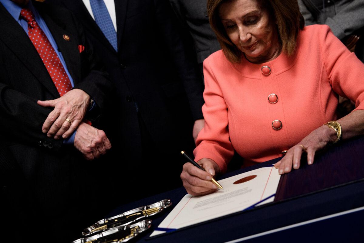 House Speaker Nancy Pelosi (D-Calif.) signs the articles of impeachment of President Donald Trump during an engrossment ceremony on Capitol Hill in Washington on Jan. 15, 2020. (Brendan Smialowski/AFP via Getty Images)