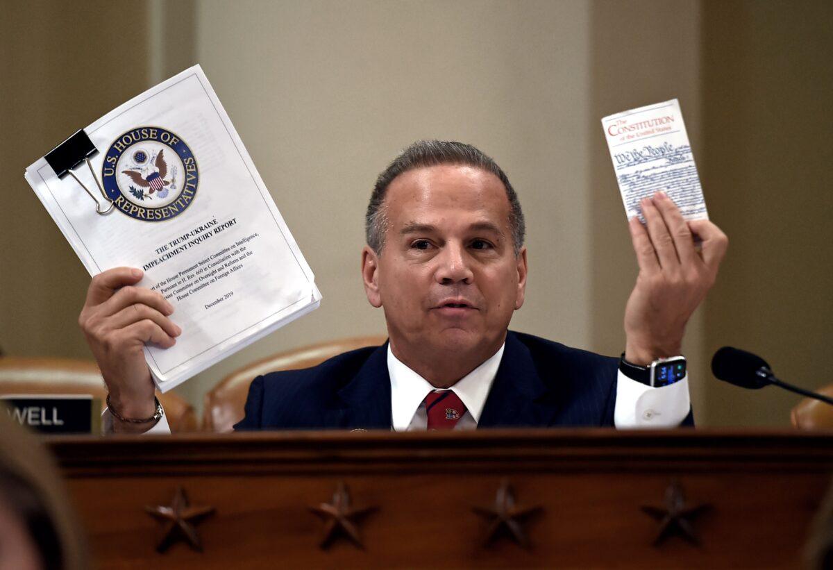 Rep. David Cicilline (D-R.I.) holds up a copy of the Trump-Ukraine Impeachment inquiry report and a copy of the Constitution of the United States in the Longworth House Office Building in Washington on Dec. 12, 2019. (Olivier Douliery/AFP via Getty Images)