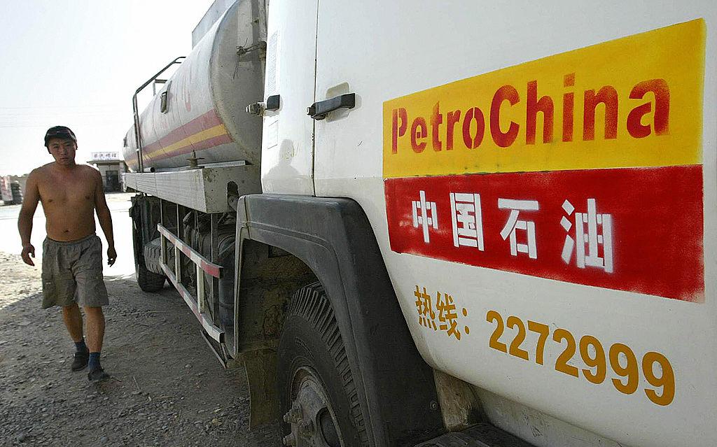 A man walks beside a PetroChina oil delivery vehicle. China's ambition to quadruple its gross domestic product within two decades will see oil consumption exceed 400 million tons a year by 2020, with imports accounting for half its needs. (Frederic J. Brown/AFP via Getty Images)