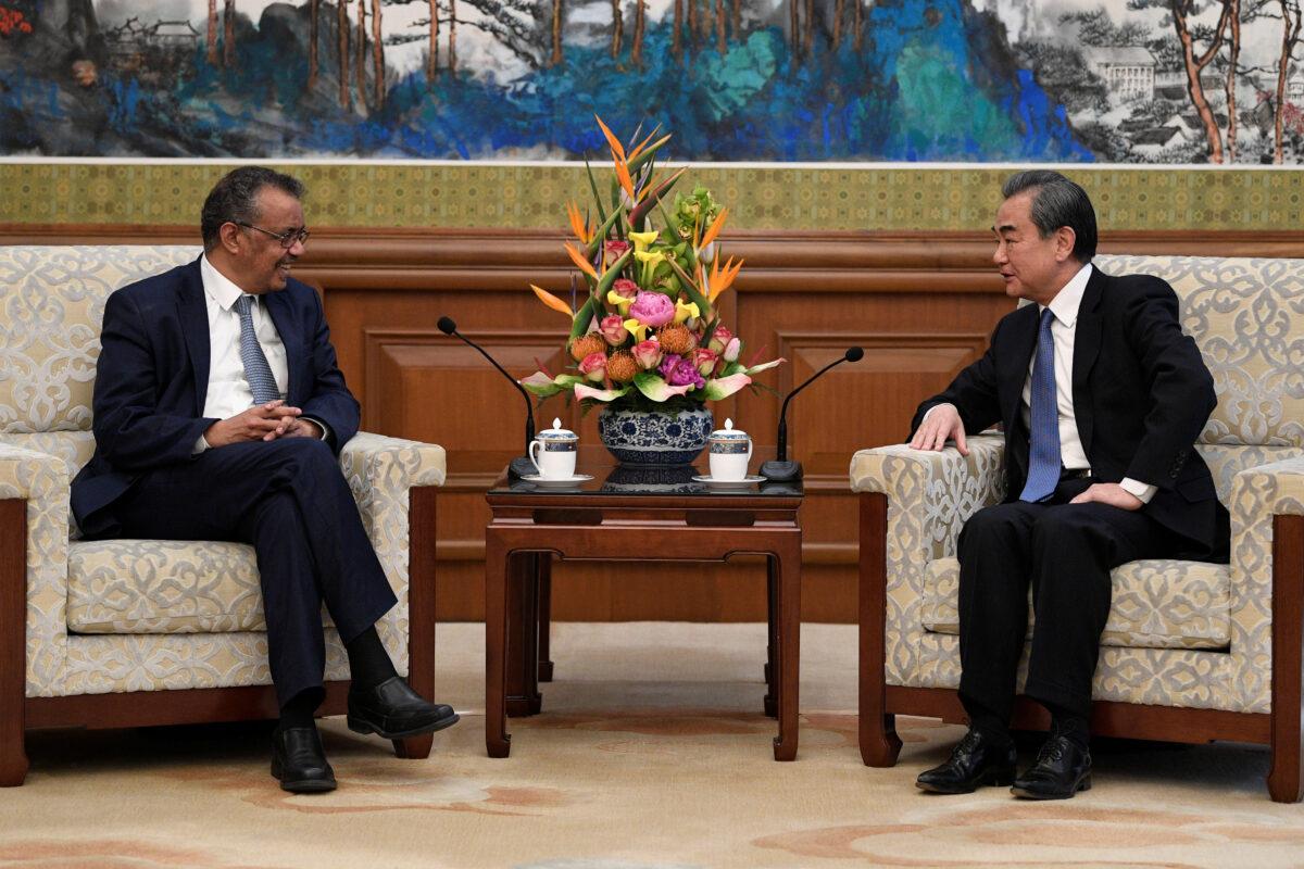Tedros Adhanom Ghebreyesus, director-general of the World Health Organization, meets with Chinese Foreign Minister Wang Yi before a meeting at the Diaoyutai State Guesthouse in Beijing, China, on Jan. 28, 2020. (Naohiko Hatta/Pool via Reuters)