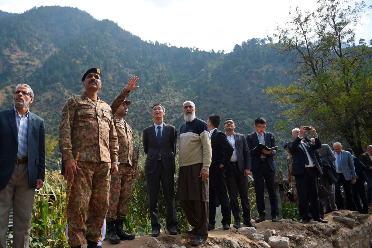 A Pakistani army officer (3L) briefs Chinese Ambassador to Pakistan Yao Jing (4L) and Pakistani army Major General Asif Ghafoor (2L) and foreign diplomats during their visit at a cross border shelling affected area in Jura, a village of Neelum valley in Pakistan-administered Kashmir on Oct. 22, 2019. (Farooq Naeem/AFP via Getty Images)