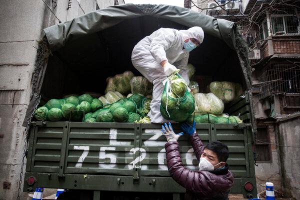 A employee wears a protective mask whilst carrying vegetables from trucks at a hospital in Wuhan, China, on Feb. 10, 2020. (Stringe/Getty Images)