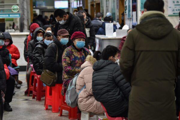 People wearing face masks to help stop the spread of a deadly virus that began in the city wait at Wuhan Red Cross Hospital in Wuhan on Jan. 24, 2020. (Hector Retamal/AFP via Getty Images)