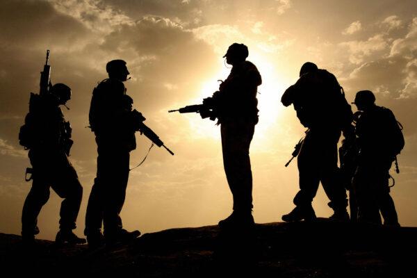 British soldiers from 21 Air Assault Battery Royal Artillery are silhouetted against the sky as they provide security for a meeting with the Afghan National Police at the fortress Qala-e-Bost in Lashkar Gah, Helmand Province, on May 17, 2006. (John D. McHugh/AFP via Getty Images)