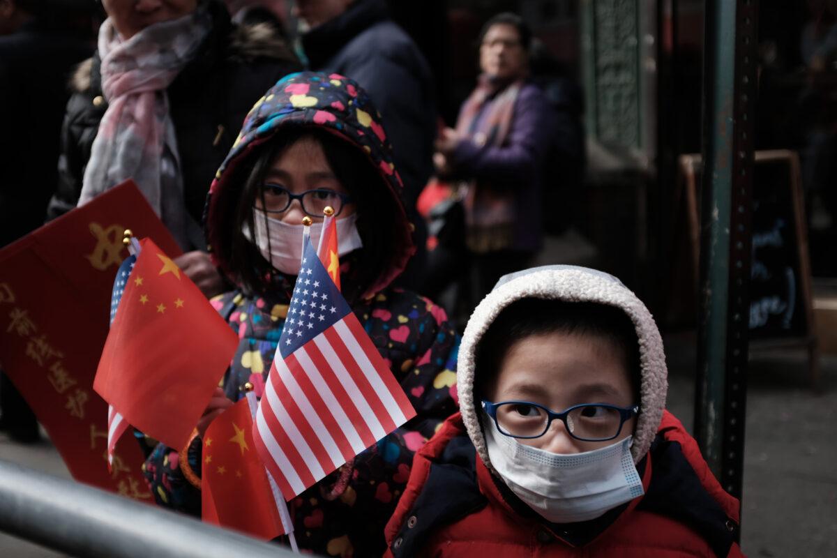 Children wearing surgical masks watch the annual Lunar New Year Parade in Manhattan's Chinatown in New York City on Feb. 9, 2019. (Spencer Platt/Getty Images)